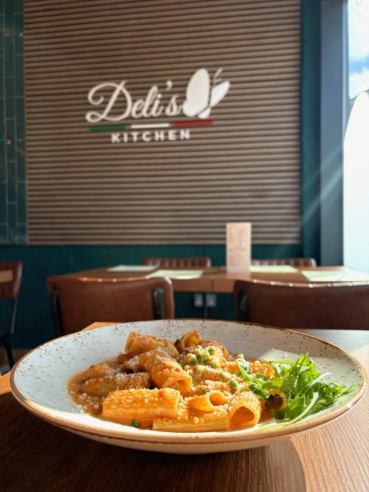 Deli's Kitchen pasta dish with restaurant logo